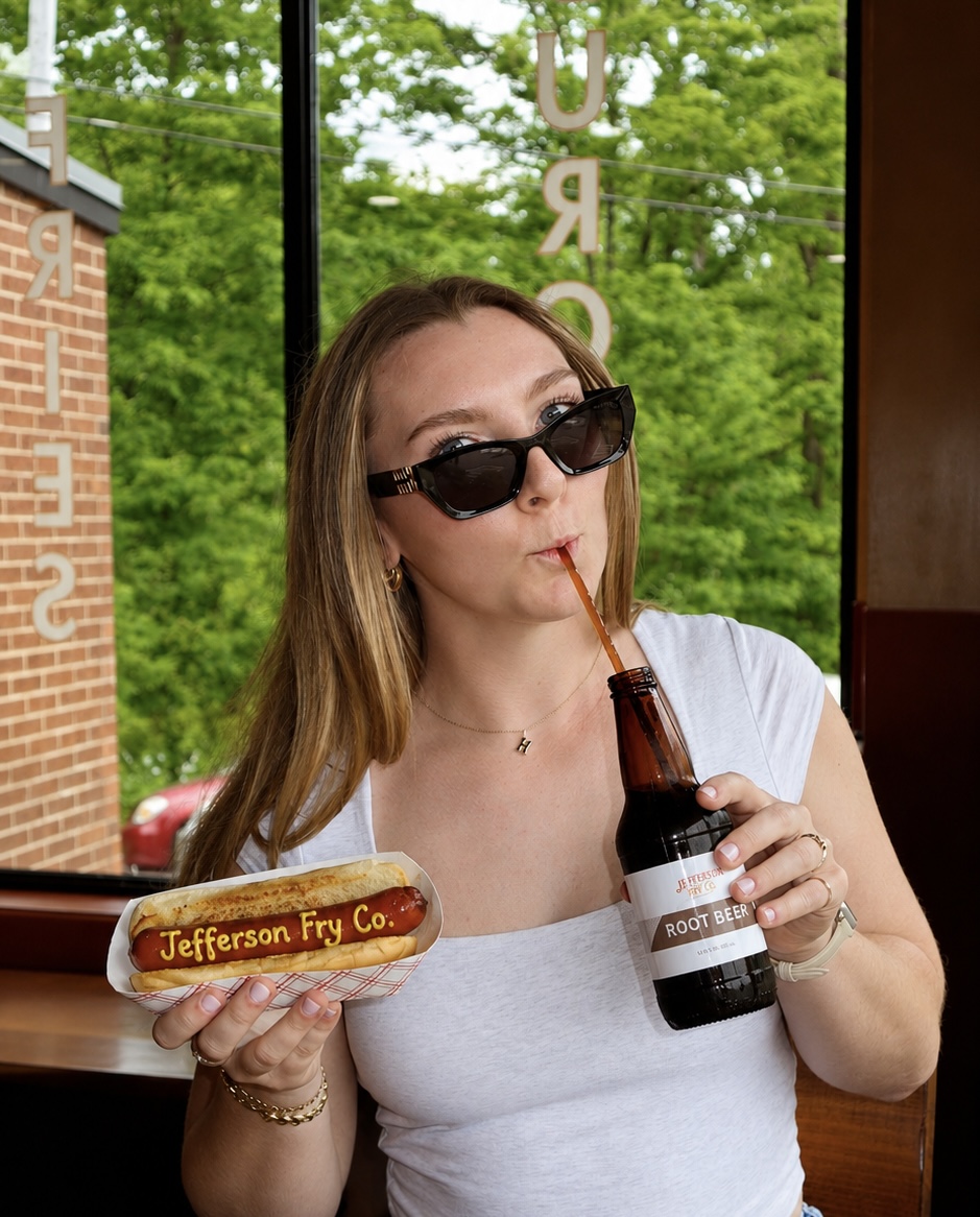 A guest posing with Jefferson Fry Co. food and root beer.